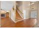 Open foyer with wood floors, staircase, and a view of the living room and front door at 8985 Edgewood Ln, Highlands Ranch, CO 80130