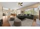 Bright living room featuring hardwood floors, an oversized sectional couch, and direct access to the kitchen at 8985 Edgewood Ln, Highlands Ranch, CO 80130