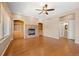 Spacious living room with hardwood floors, a brick fireplace, and built-in shelving at 8985 Edgewood Ln, Highlands Ranch, CO 80130