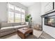 Cozy living room with fireplace, large windows, neutral tones, and lots of natural light at 3502 Nez Perce Trl, Castle Rock, CO 80109
