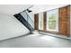 Living area with exposed brick, large windows, and staircase to the upper level at 2193 Arapahoe St # 15, Denver, CO 80205