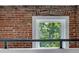 This close-up showcases exposed brick wall and a scenic window view from the loft at 2193 Arapahoe St # 15, Denver, CO 80205