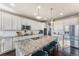 Modern kitchen with a large island, granite countertops, stainless steel appliances, and white cabinets at 18984 W 85Th Blf, Arvada, CO 80007