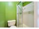 This bathroom features green walls, white tile in the shower, and a toilet at 11922 Bellaire St # F, Thornton, CO 80233