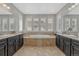 Spacious primary bath featuring a large soaking tub, dual sinks, and plantation shutters for privacy at 26566 E Peakview Dr, Aurora, CO 80016