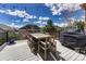 Outdoor deck features a dining table, chairs, grill, and decorative string lights at 26566 E Peakview Dr, Aurora, CO 80016
