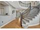 Grand foyer featuring a curved staircase with wrought iron railings and hardwood flooring at 26566 E Peakview Dr, Aurora, CO 80016