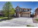 Inviting two-story home with a three-car garage, stone accents, and manicured front yard at 26566 E Peakview Dr, Aurora, CO 80016