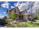 Charming front exterior featuring a covered porch, lush landscaping, and a well-maintained lawn at 26566 E Peakview Dr, Aurora, CO 80016