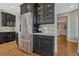 Kitchen with stainless steel refrigerator, black cabinets, granite counters, and hardwood floors at 26566 E Peakview Dr, Aurora, CO 80016