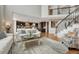 Bright and airy living room showcases open floor plan with dark kitchen cabinetry and staircase at 26566 E Peakview Dr, Aurora, CO 80016