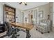 Cozy home office with french doors, a large wood desk, and a comfortable sitting area at 26566 E Peakview Dr, Aurora, CO 80016