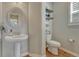 Stylish powder room features pedestal sink, floating shelves, and wood-look floors at 26566 E Peakview Dr, Aurora, CO 80016