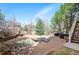 Beautiful backyard with a stone-lined stream, brick patio, lush landscaping, and outdoor seating area at 4913 Cathay Ct, Denver, CO 80249