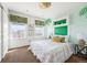 Bright bedroom with palm-leaf accents, featuring two windows and a modern bed frame at 4913 Cathay Ct, Denver, CO 80249