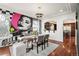 Eclectic dining room featuring unique wall art, stylish lighting, and a view into the spacious kitchen at 4913 Cathay Ct, Denver, CO 80249