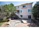 Exterior view of a multi-story house with a backyard featuring a stone-lined creek, brick patio, and staircase at 4913 Cathay Ct, Denver, CO 80249