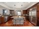 Gourmet kitchen with stainless steel appliances, granite countertops, a central island, and rich wood cabinetry at 4913 Cathay Ct, Denver, CO 80249