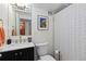 Well-lit bathroom featuring a modern vanity, framed art, and patterned shower curtain creating an aesthetically pleasing space at 1150 Vine St # 306, Denver, CO 80206