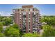 Full exterior shot of a tall building with balconies reveals its multi-story design and urban surroundings surrounded by trees at 1150 Vine St # 306, Denver, CO 80206
