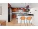 Modern kitchen with stainless steel appliances, dark cabinets, breakfast bar, and stylish pendant lighting at 1150 Vine St # 306, Denver, CO 80206