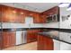 Close-up of a kitchen with stainless steel appliances, dark countertops, and custom wood cabinetry at 1150 Vine St # 306, Denver, CO 80206
