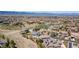 Expansive aerial view of a residential area with houses, green spaces, and a pond in the background at 10704 Flowerburst Ct, Highlands Ranch, CO 80126
