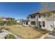 View of backyard with lawn, patio, and playset, highlighting the home's stone and stucco construction at 10704 Flowerburst Ct, Highlands Ranch, CO 80126
