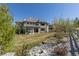 Spacious backyard with stone and grass, featuring a playground and seating area under a covered patio at 10704 Flowerburst Ct, Highlands Ranch, CO 80126