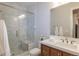 Bathroom featuring a glass-enclosed shower, marble tile, wooden vanity, and ample natural light at 10704 Flowerburst Ct, Highlands Ranch, CO 80126