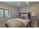 Cozy bedroom featuring a plush bed with a decorative headboard, soft bedding, and natural light from the window at 10704 Flowerburst Ct, Highlands Ranch, CO 80126