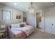 Bright bedroom with a chandelier, window seat, and view to the bathroom at 10704 Flowerburst Ct, Highlands Ranch, CO 80126