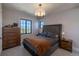 Cozy bedroom featuring a plush bed, wood dresser, and plenty of natural light at 10704 Flowerburst Ct, Highlands Ranch, CO 80126