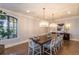 Dining room with a long table, modern chandeliers, and large windows at 10704 Flowerburst Ct, Highlands Ranch, CO 80126