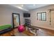 Home gym featuring laminate wood flooring, a large mirror, weight rack, and mounted TV at 10704 Flowerburst Ct, Highlands Ranch, CO 80126
