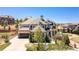 Expansive home showcasing a stone facade, a three-car garage, and professionally landscaped front yard at 10704 Flowerburst Ct, Highlands Ranch, CO 80126