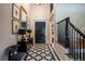 Elegant foyer with a black and white marble floor, staircase, and black entry door at 10704 Flowerburst Ct, Highlands Ranch, CO 80126