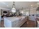 Bright, open kitchen with a large center island, farmhouse sink, stainless appliances, and decorative pendant lights at 10704 Flowerburst Ct, Highlands Ranch, CO 80126