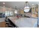 Bright kitchen with an expansive island with seating, elegant lighting, and luxury appliances at 10704 Flowerburst Ct, Highlands Ranch, CO 80126