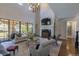 Elegant living room featuring high ceilings, fireplace, large windows, and stylish furniture at 10704 Flowerburst Ct, Highlands Ranch, CO 80126