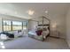 Bright main bedroom with a four-poster bed, lots of natural light, and views of the green outdoors at 10704 Flowerburst Ct, Highlands Ranch, CO 80126