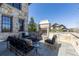 Cozy outdoor patio featuring a stone fireplace, comfortable seating, and stylish decor at 10704 Flowerburst Ct, Highlands Ranch, CO 80126
