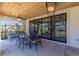 Stylish outdoor patio with wood ceiling, black framed windows, and comfortable seating area with a dining table at 10704 Flowerburst Ct, Highlands Ranch, CO 80126
