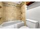 Bathroom with a tiled shower and bath combination and a white toilet at 7729 S Cove Cir, Centennial, CO 80122