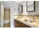 Bathroom vanity featuring double sinks, tile backsplash, decorative mirrors, and tile flooring at 7729 S Cove Cir, Centennial, CO 80122
