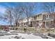Serene row of townhomes with snow-covered front yards, accentuated by mature trees and a cozy picnic area at 7729 S Cove Cir, Centennial, CO 80122
