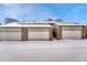 Row of garages featuring brick accents and snow covered roofs at 7729 S Cove Cir, Centennial, CO 80122