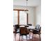 Bright dining area featuring a round table, modern seating, and a stylish pendant light fixture at 12699 W 84Th Dr, Arvada, CO 80005