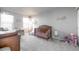 This gray carpeted bedroom features a wood crib and neutral decor at 9334 Sedalia St, Commerce City, CO 80022