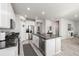 Open-concept kitchen with stainless steel appliances and barstool seating at 9334 Sedalia St, Commerce City, CO 80022